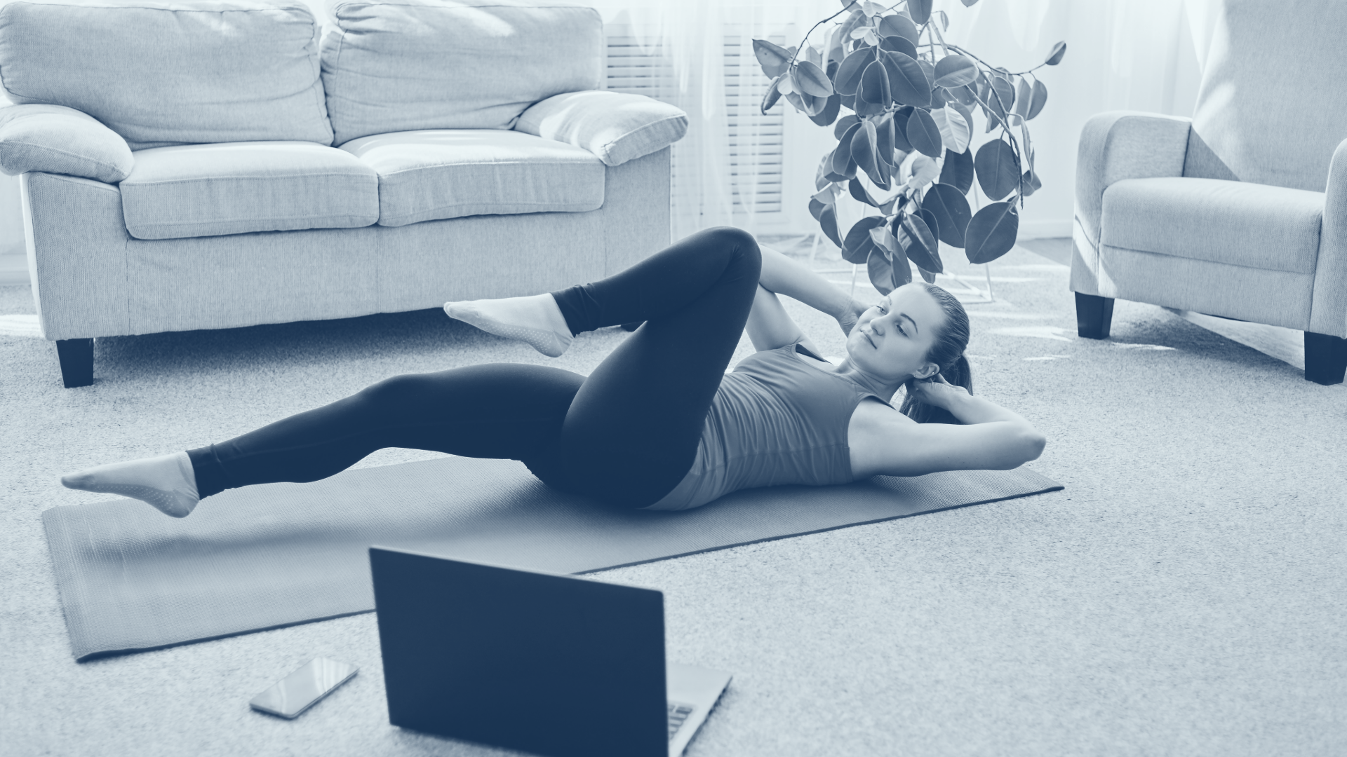 woman doing exercise at home while watching computer screen